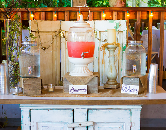 Pink lemonade stand at a wedding reception offers drinks for the guests.