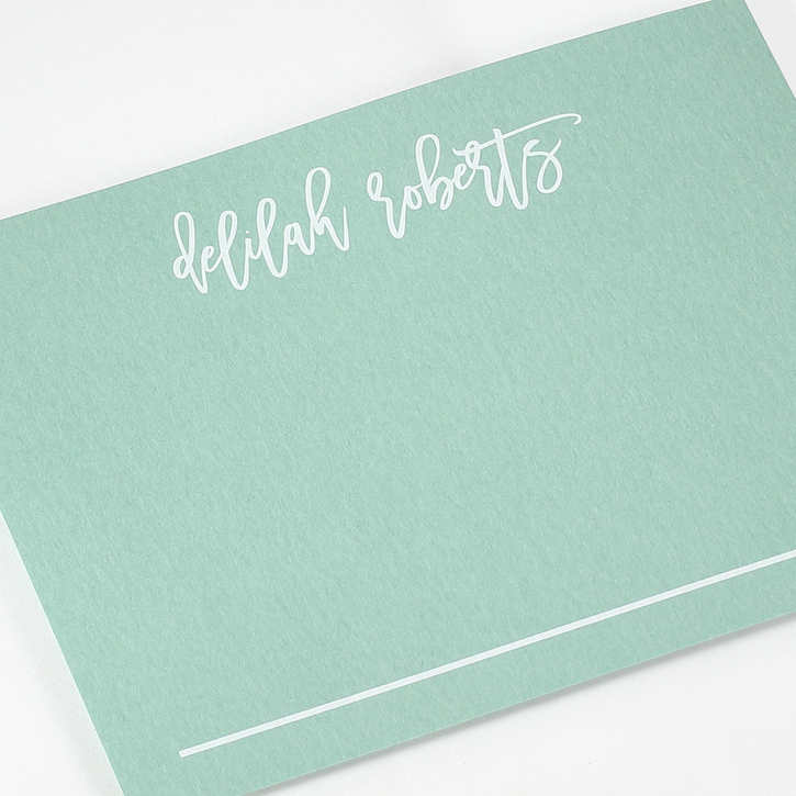 Flat notecard personalized with white ink on dark colored paper