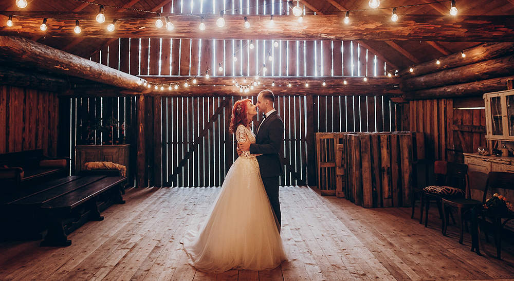 Wedding couple sharing a dance in a rustic barn