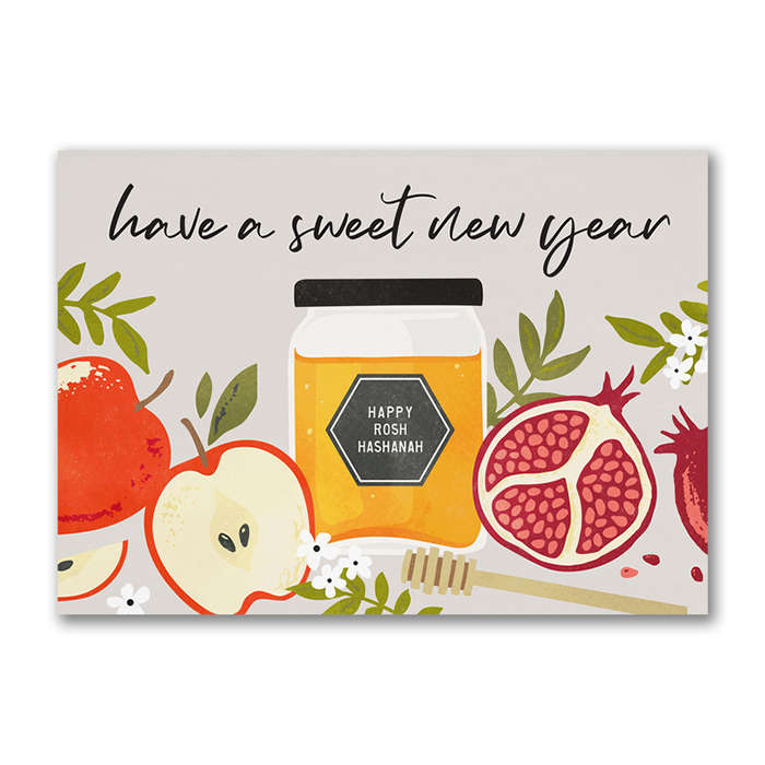 A Rosh Hashanah card featuring a jar of honey surrounded by apples and pomegranates with greeting “have a sweet new year.” 