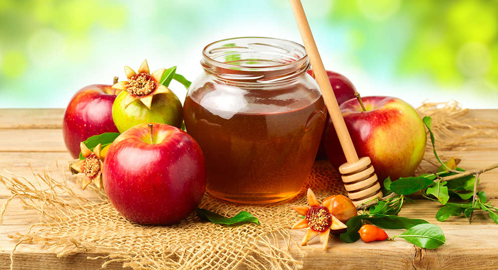 An image celebrating the tradition of eating apples dipped in honey on Rosh Hashanah
