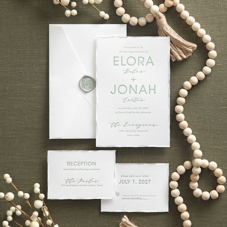 A gorgeous wedding invitation suite featuring letterpress printing, a modern monogram, and a pearl foil deckle edge is shown