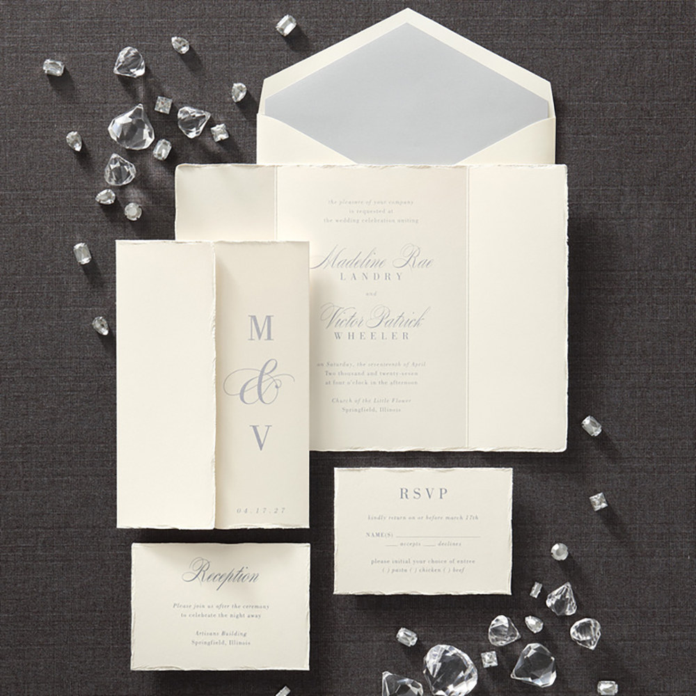 Gatefold wedding invitation with deckle edges featuring the couple’s initials on one of the front panels