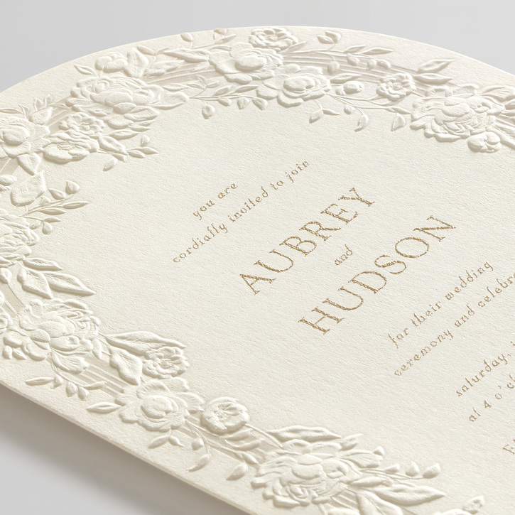 A response card is blind and embossed with a delicate rose design.