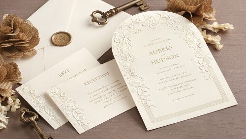 Arch-shaped wedding invitation blind embossed with a rose trellis.