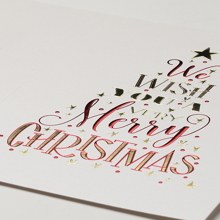 A Christmas card is foil stamped in different colors and arranged like a Christmas tree.