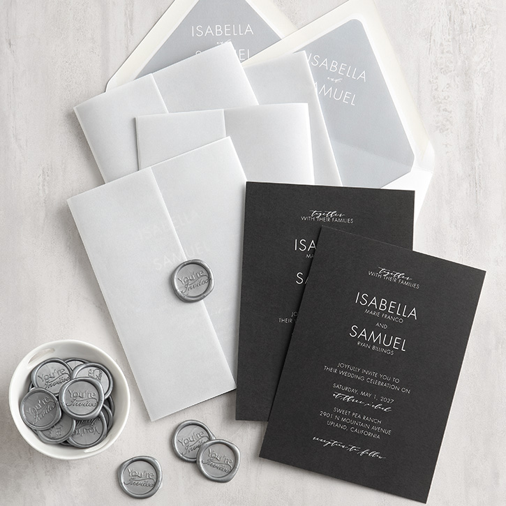 A black wedding invitation with sheer gatefold pocket and silver wax seals. 