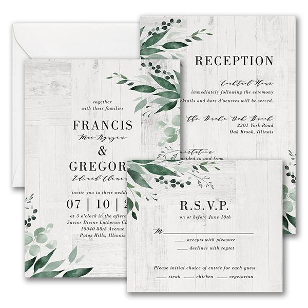 A digitally printed wedding invitation with greenery design and wood panel backdrop.