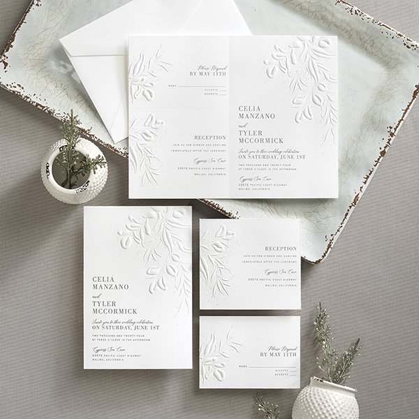 A sep 'n send wedding invitation with deeply embossed leaves is designed with perforation to separate and send.