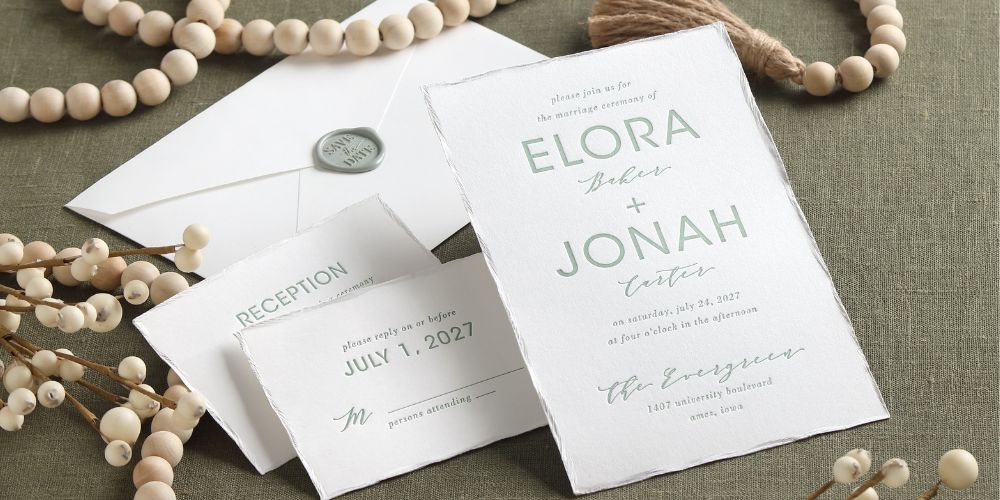 A letterpress wedding invitation suite with feather deckle edge and a peel-and-stick wax seal on the envelope. 