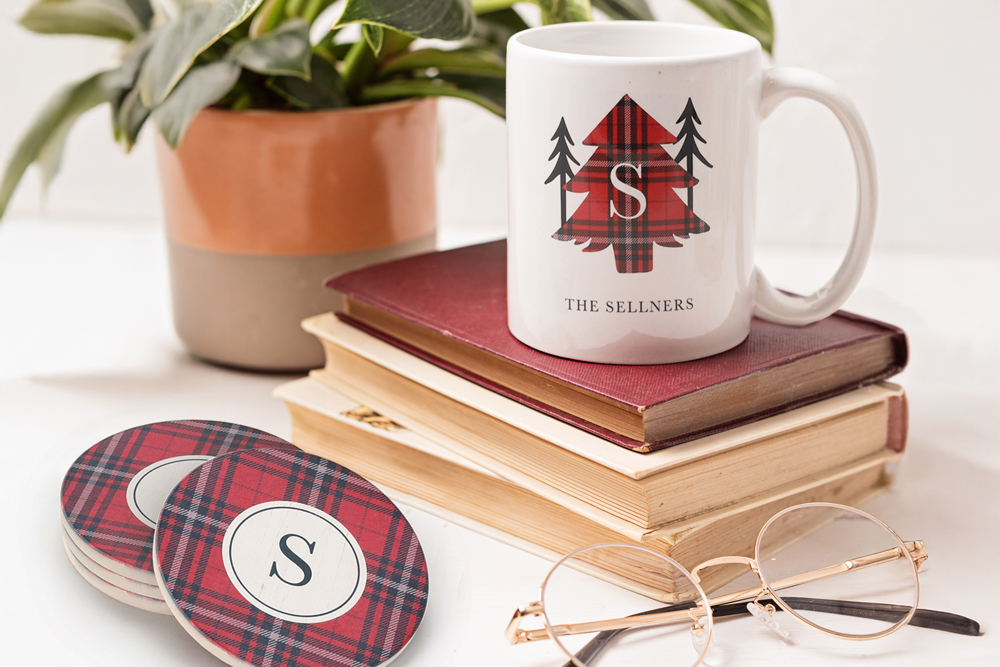 Personalized mug and coasters with plaid design on a home desk. 
